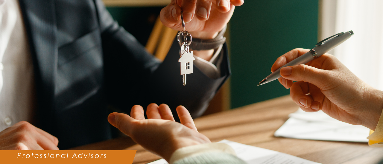 Person handing house keys to another person.